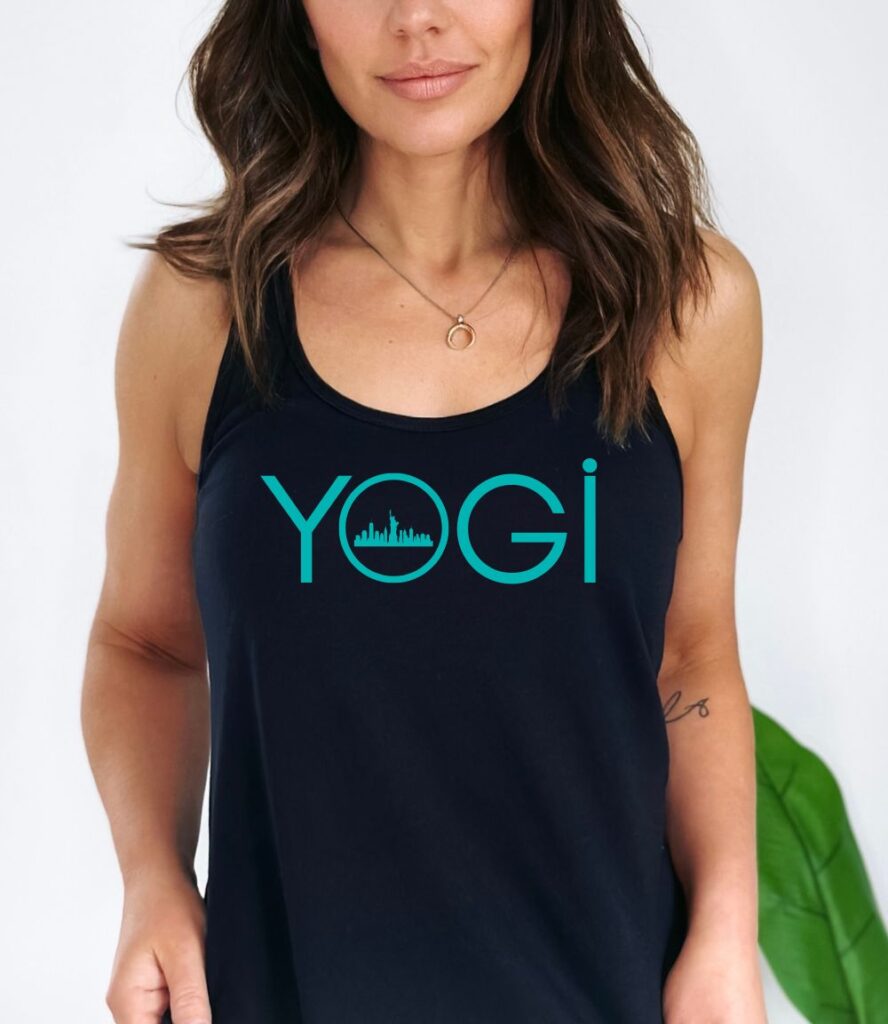 Female yogi with long brunette hair wearing a black racerback yoga tank top with a graphic of the NY city skyline and the word yogi.